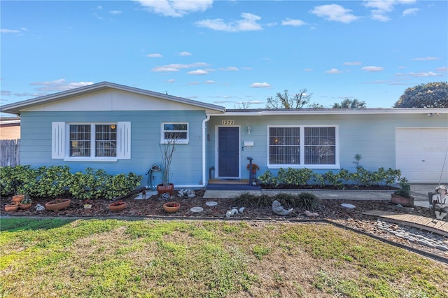 ranch-style home with a garage and a front yard