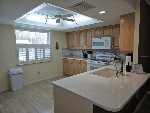 kitchen with sink, white appliances, ceiling fan, tasteful backsplash, and kitchen peninsula