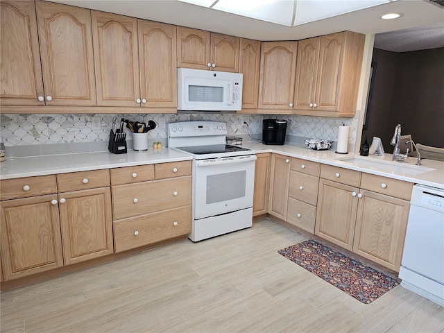 kitchen featuring tasteful backsplash, white appliances, light hardwood / wood-style floors, and sink