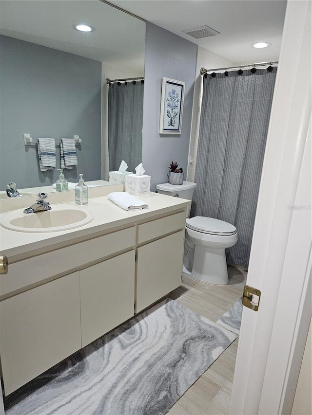 bathroom featuring vanity, toilet, and curtained shower