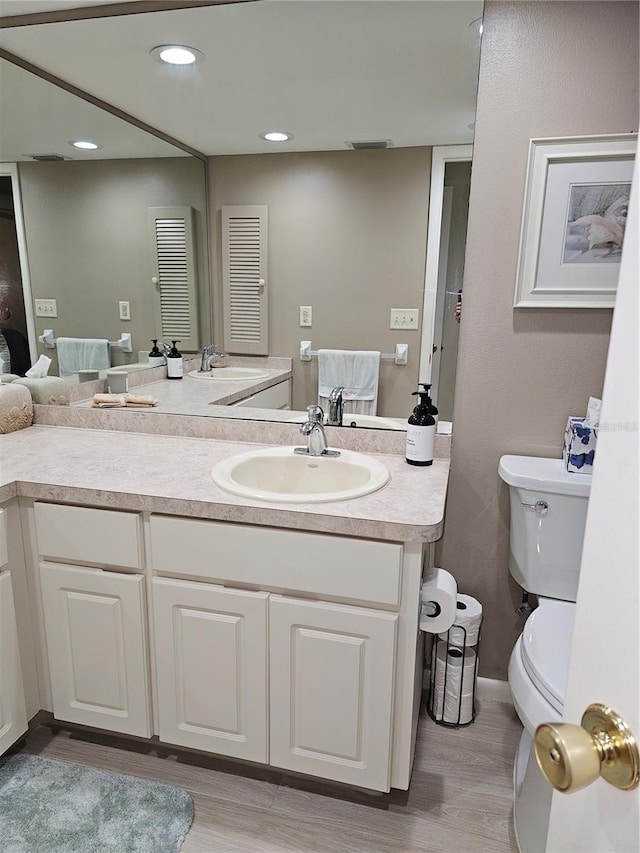 bathroom featuring vanity, hardwood / wood-style floors, and toilet