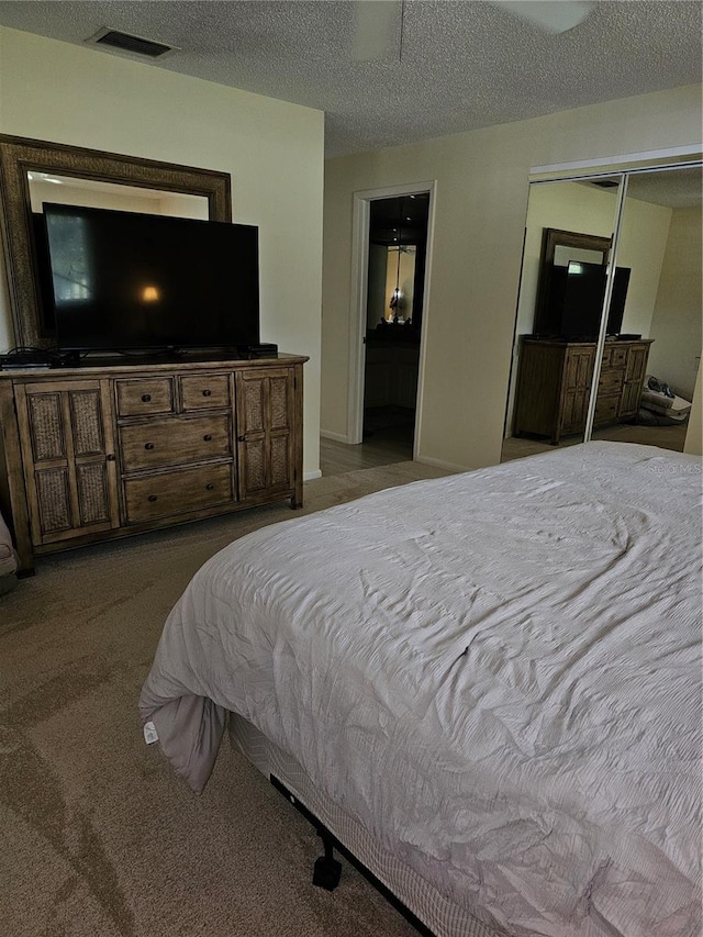 bedroom featuring light colored carpet, a closet, and a textured ceiling