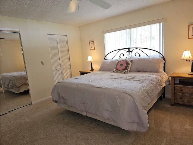 carpeted bedroom with multiple closets, ceiling fan, and a textured ceiling