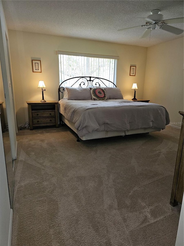 bedroom with ceiling fan, carpet, and a textured ceiling