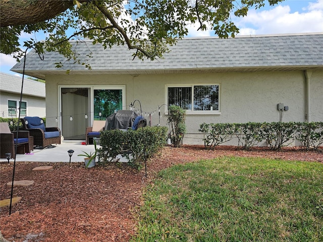 ranch-style home with a front lawn and a patio area