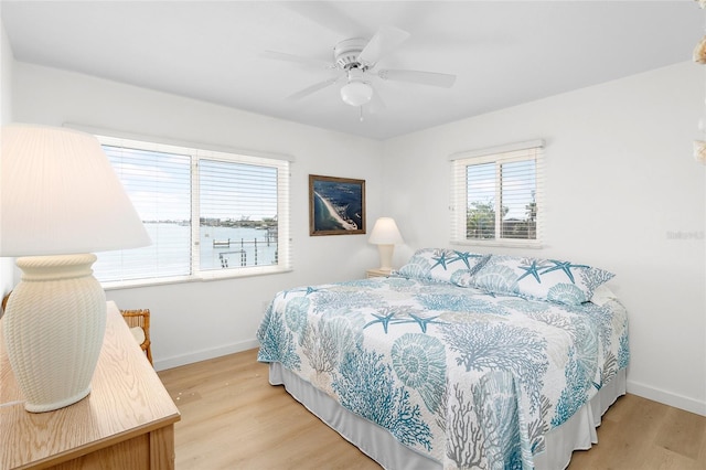 bedroom featuring light wood-type flooring, a ceiling fan, and baseboards