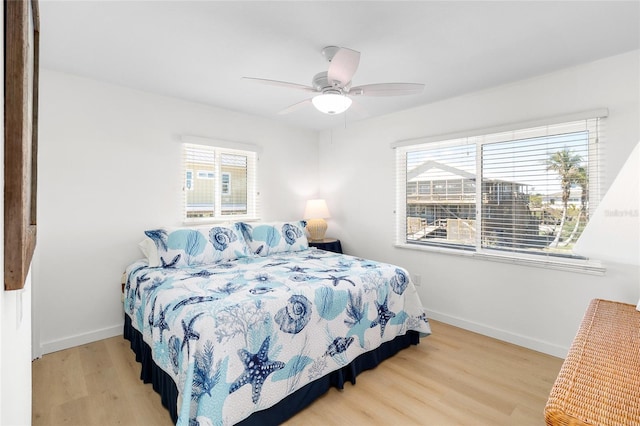 bedroom featuring ceiling fan, light wood-type flooring, and baseboards