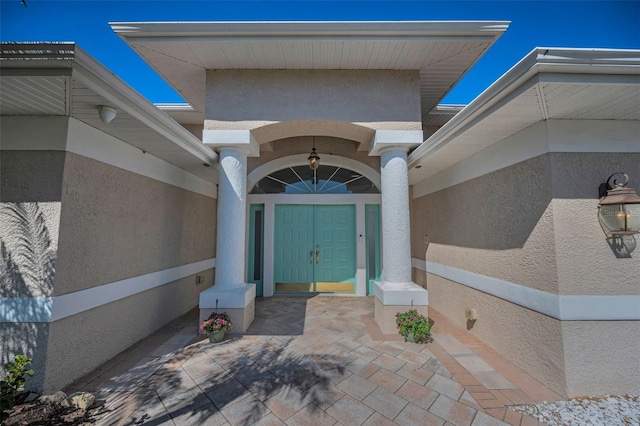 doorway to property featuring stucco siding