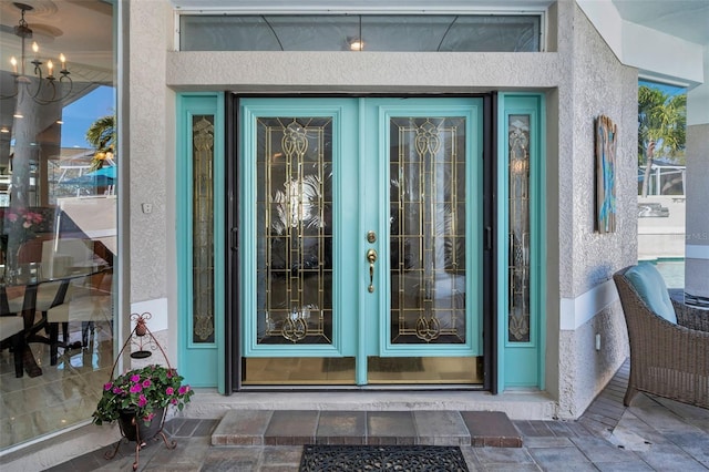 property entrance featuring french doors and stucco siding