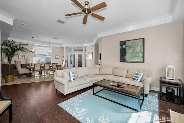 living area featuring ceiling fan, wood finished floors, visible vents, baseboards, and crown molding