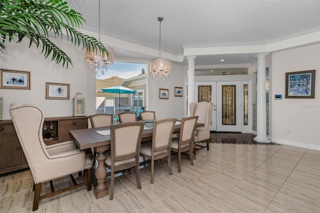 dining space with baseboards, ornamental molding, french doors, ornate columns, and a chandelier