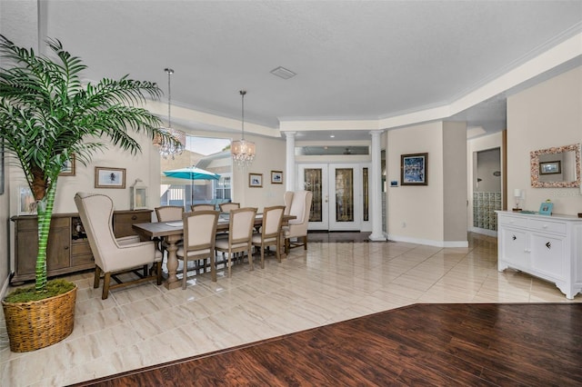 dining space featuring french doors, light wood finished floors, ornate columns, ornamental molding, and baseboards