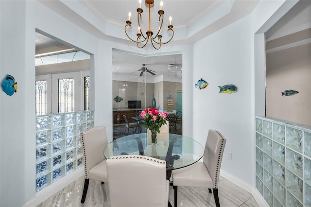 dining space featuring ornamental molding, a raised ceiling, and ceiling fan with notable chandelier