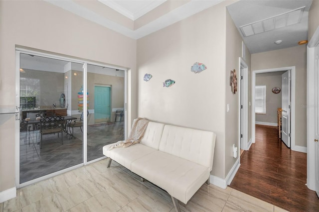 living area with ornamental molding and baseboards