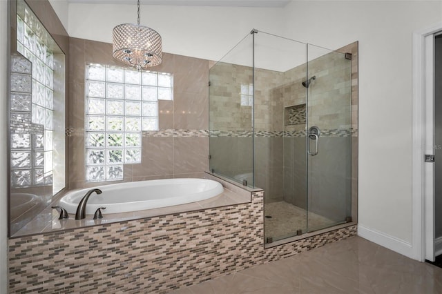 bathroom featuring a stall shower, a garden tub, and baseboards