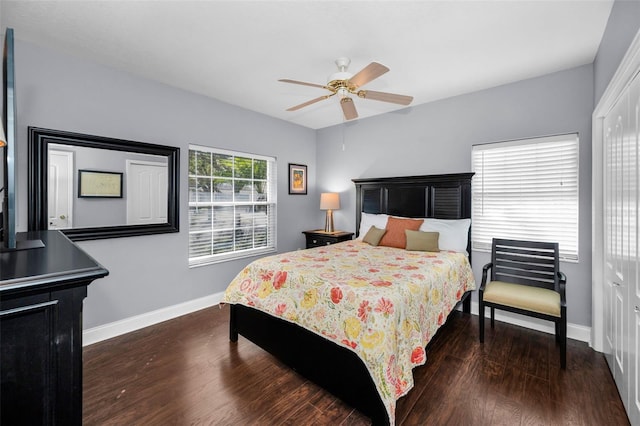 bedroom with a closet, dark wood finished floors, baseboards, and ceiling fan