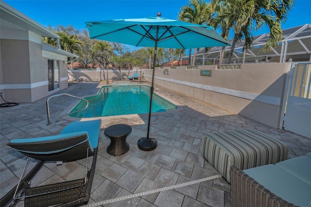 view of pool featuring glass enclosure, a fenced backyard, a fenced in pool, and a patio