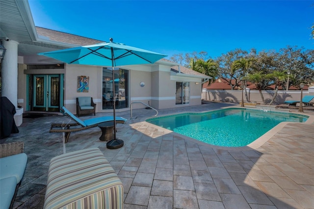 view of swimming pool with a patio area, fence, a fenced in pool, and french doors