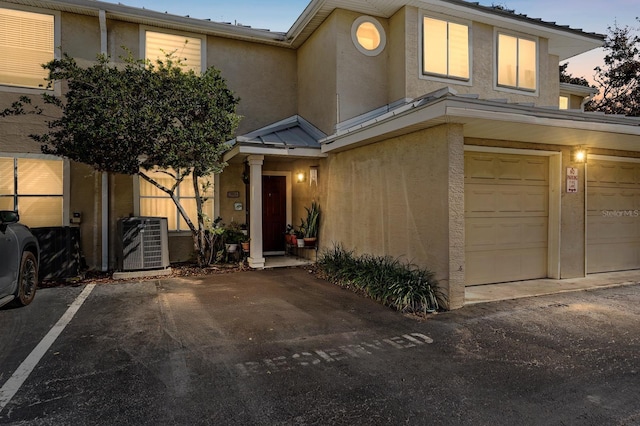 view of front of home with a garage and central AC