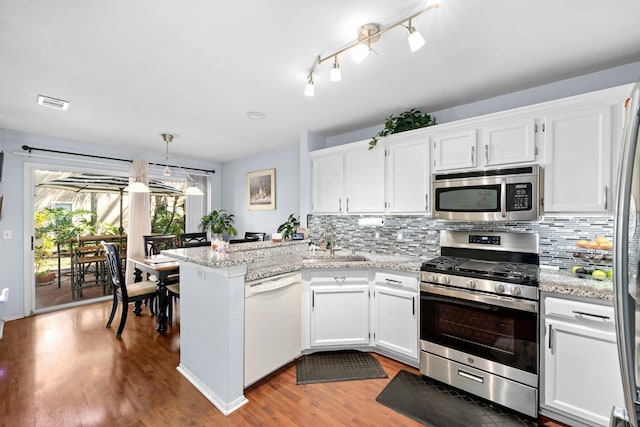 kitchen featuring sink, appliances with stainless steel finishes, hanging light fixtures, white cabinets, and kitchen peninsula