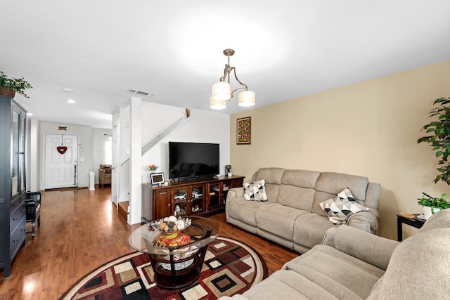 living room with dark hardwood / wood-style floors and an inviting chandelier