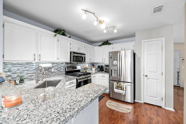 kitchen featuring sink, kitchen peninsula, white cabinets, and appliances with stainless steel finishes