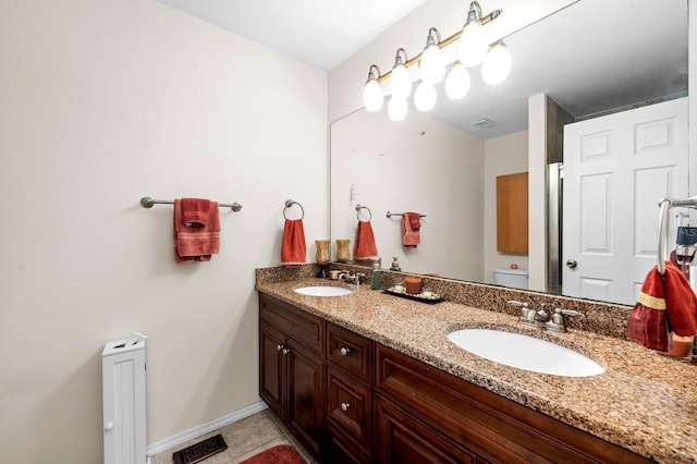 bathroom featuring vanity, tile patterned flooring, and toilet