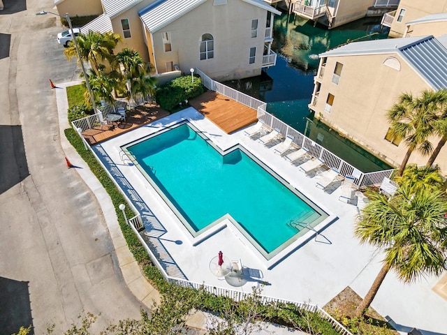 view of swimming pool with a water view and a patio area