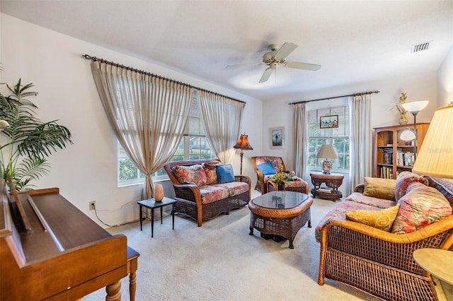 living area featuring light carpet, ceiling fan, and visible vents