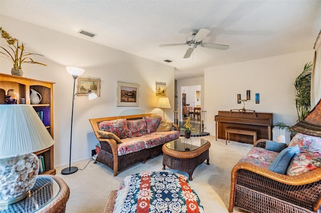 carpeted living area featuring visible vents and a ceiling fan