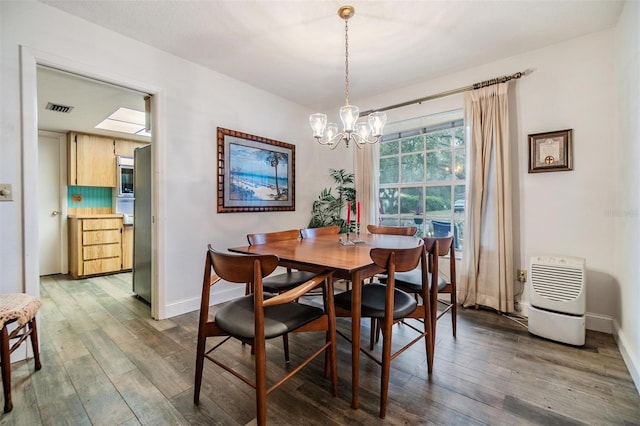 dining room with visible vents, baseboards, and wood finished floors