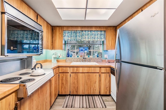 kitchen with light countertops, appliances with stainless steel finishes, and a sink