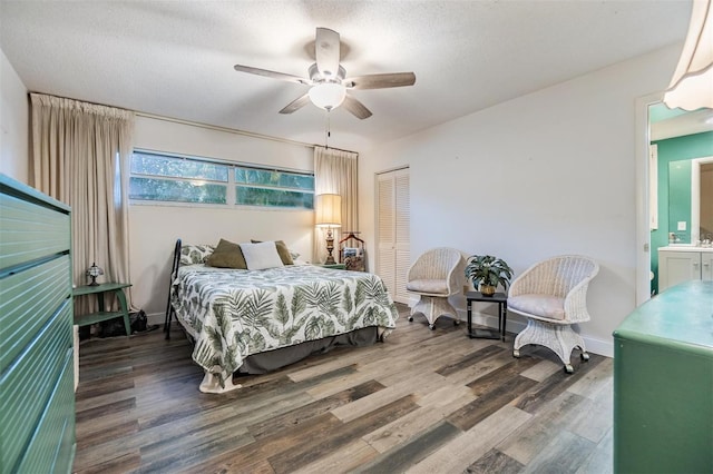 bedroom featuring baseboards, ceiling fan, wood finished floors, a textured ceiling, and a closet