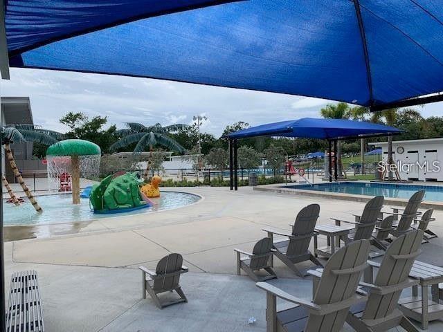 exterior space with a patio area, fence, and a water play area