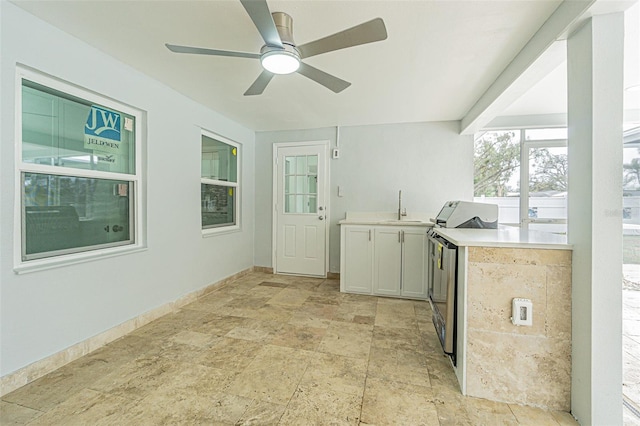 interior space featuring ceiling fan, sink, and white cabinets