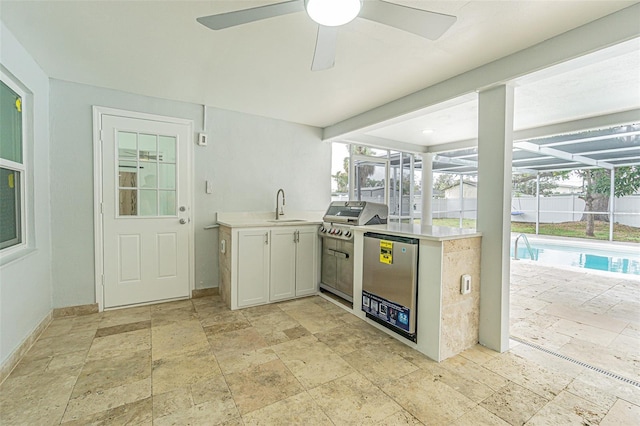 kitchen with refrigerator, white cabinetry, sink, ceiling fan, and kitchen peninsula