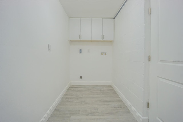 washroom featuring cabinets, hookup for a washing machine, and light wood-type flooring