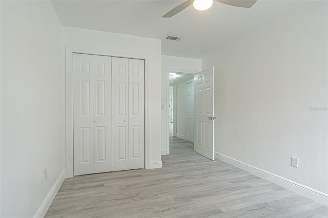 unfurnished bedroom featuring light hardwood / wood-style flooring, a closet, and ceiling fan