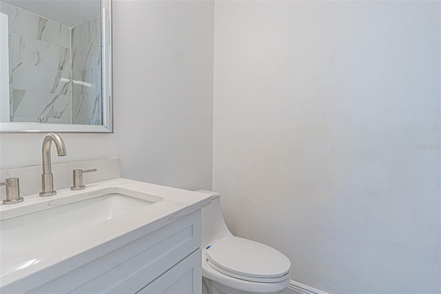 bathroom with walk in shower, vanity, and toilet