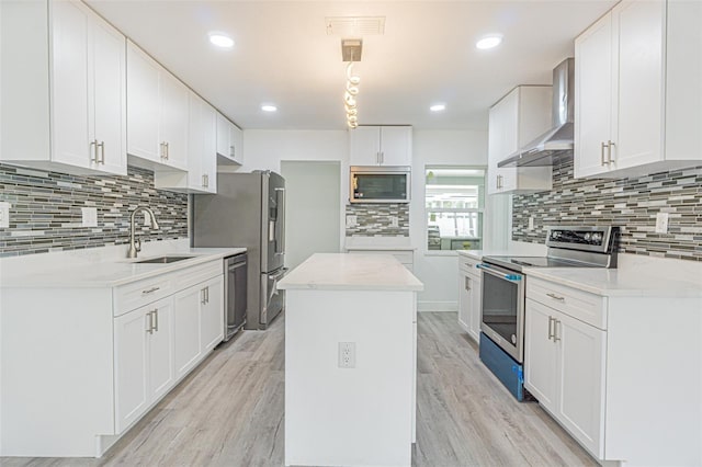 kitchen featuring white cabinetry, sink, stainless steel appliances, and wall chimney exhaust hood