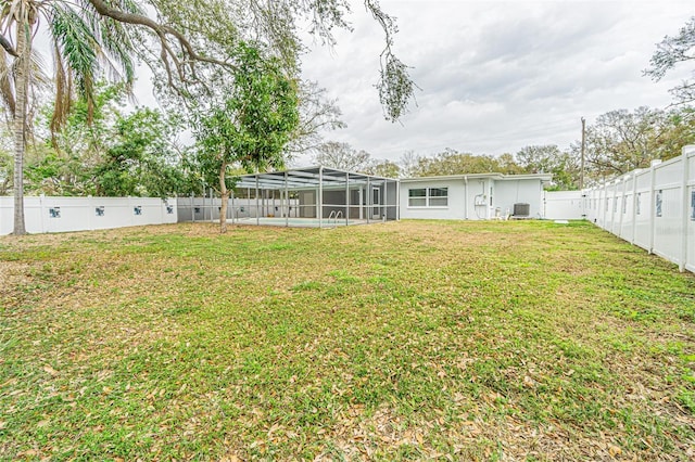 back of property with cooling unit, a yard, and glass enclosure