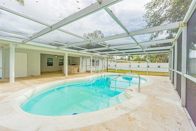 view of swimming pool featuring a lanai and a patio area