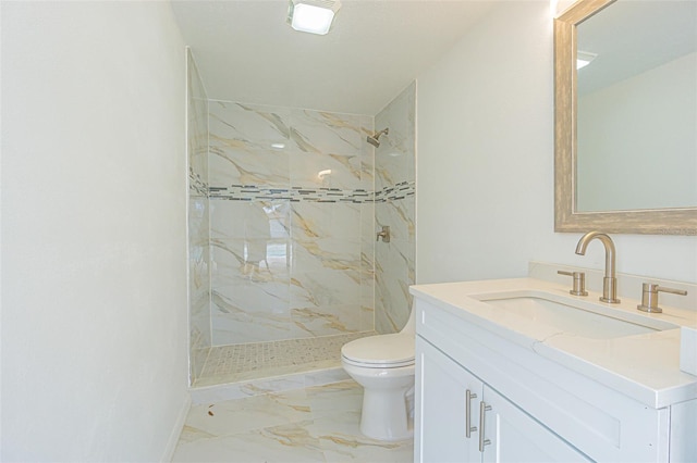 bathroom with vanity, toilet, and a tile shower