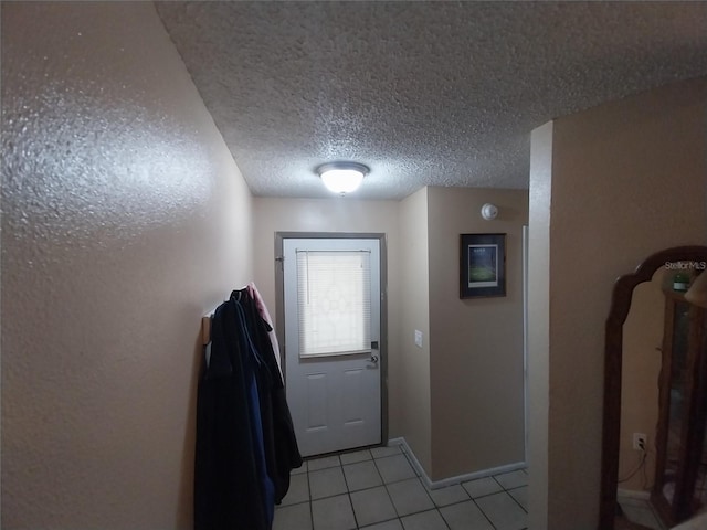 doorway to outside with light tile patterned flooring and a textured ceiling