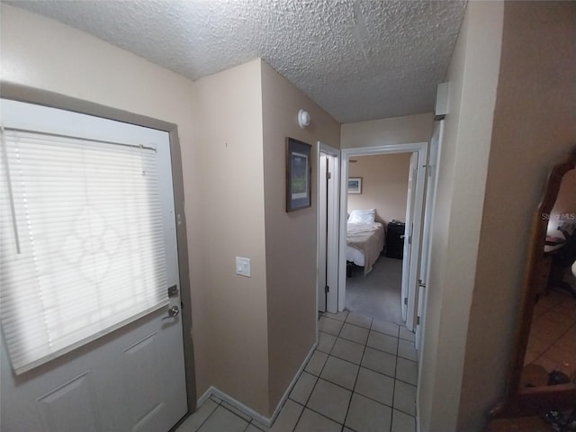 interior space with light tile patterned floors and a textured ceiling