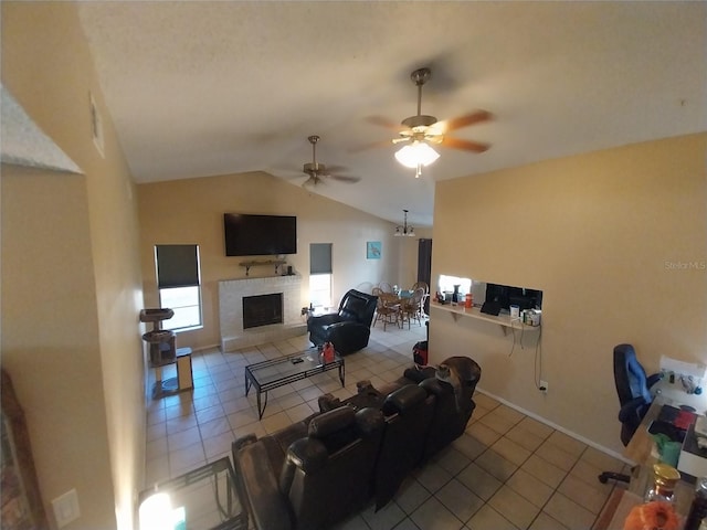 tiled living room featuring vaulted ceiling, a brick fireplace, and ceiling fan