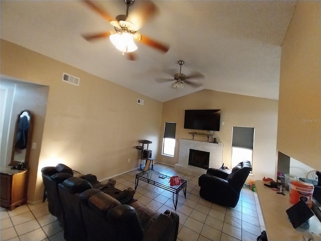 tiled living room with lofted ceiling, a brick fireplace, and ceiling fan