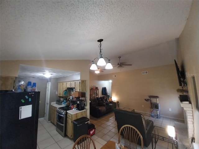 kitchen featuring lofted ceiling, a textured ceiling, light tile patterned floors, black refrigerator, and double oven range