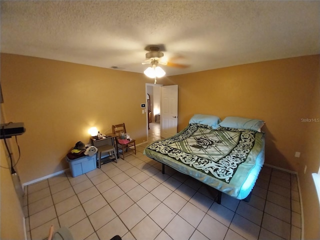 bedroom featuring tile patterned flooring, ceiling fan, and a textured ceiling