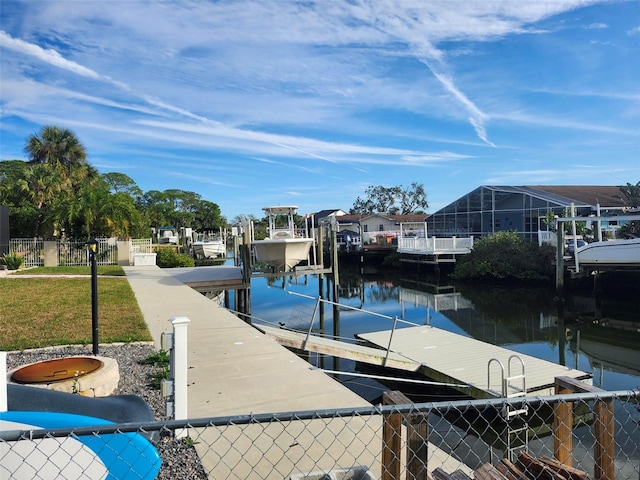 dock area with a residential view, a water view, fence, and boat lift